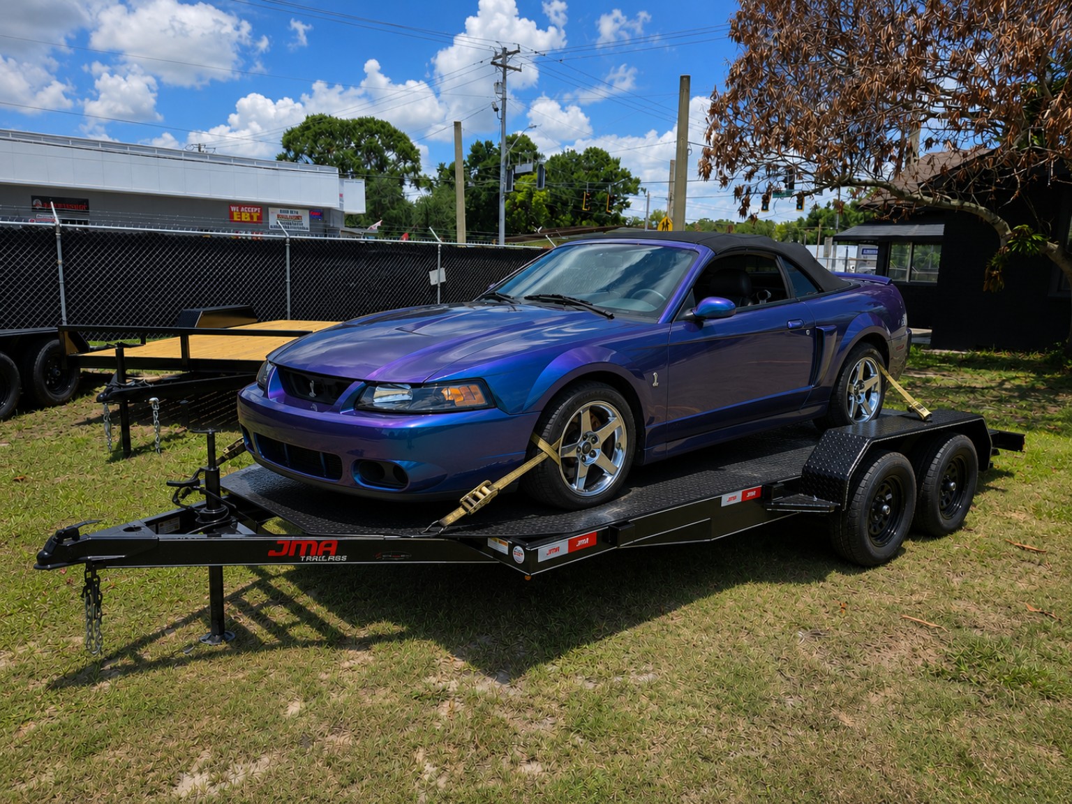 Mustang secured on a black car hauler